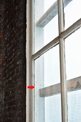 <p>Detail van het kozijn van één van de vensters in de achtergevel van Oudestraat 100. Bij de rode pijl is het spoor van de oude wisseldorpel te zien.  </p>
